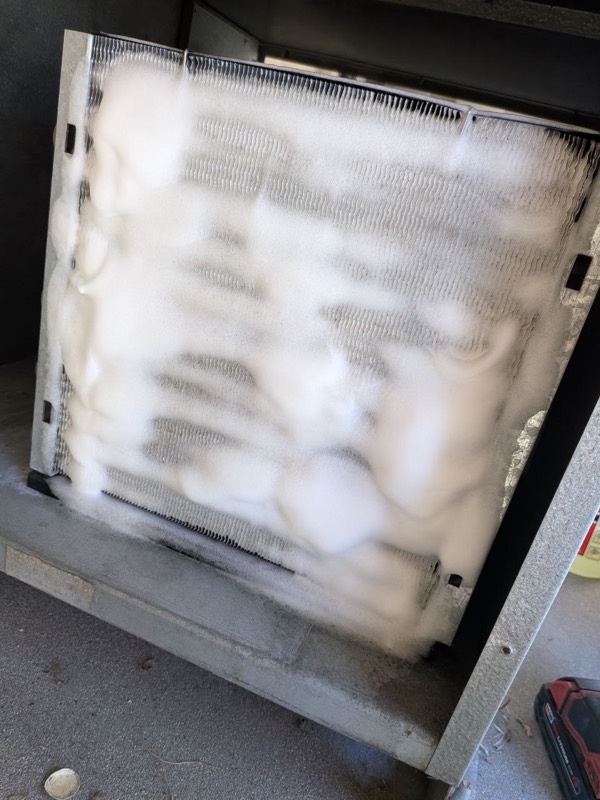 Condenser coil of a wine cellar cooling unit being cleaned with foam