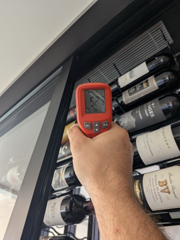 Technician checking wine cellar temperature with an infrared thermometer