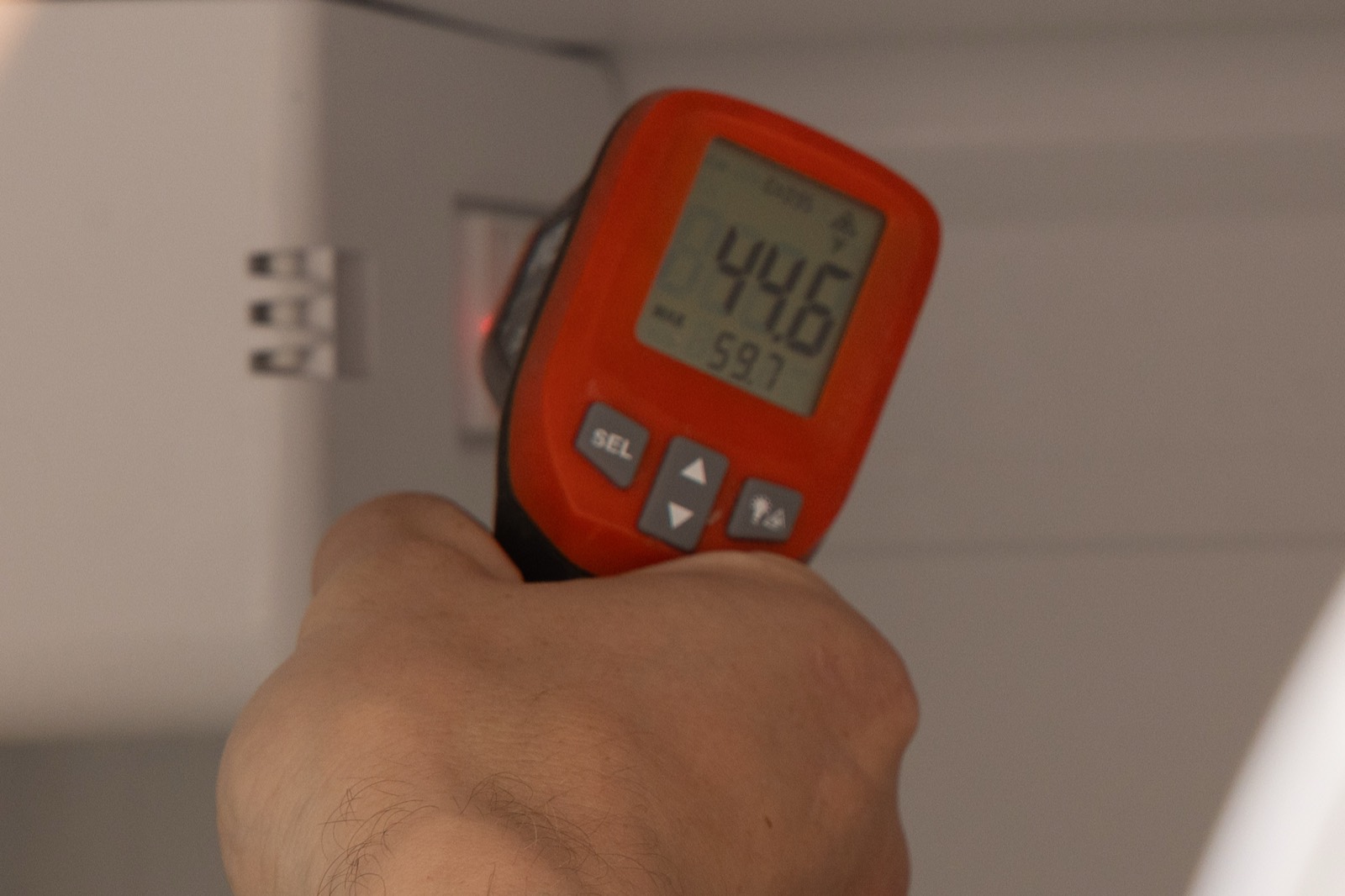 Infrared thermometer reading an appliance temperature during diagnosis