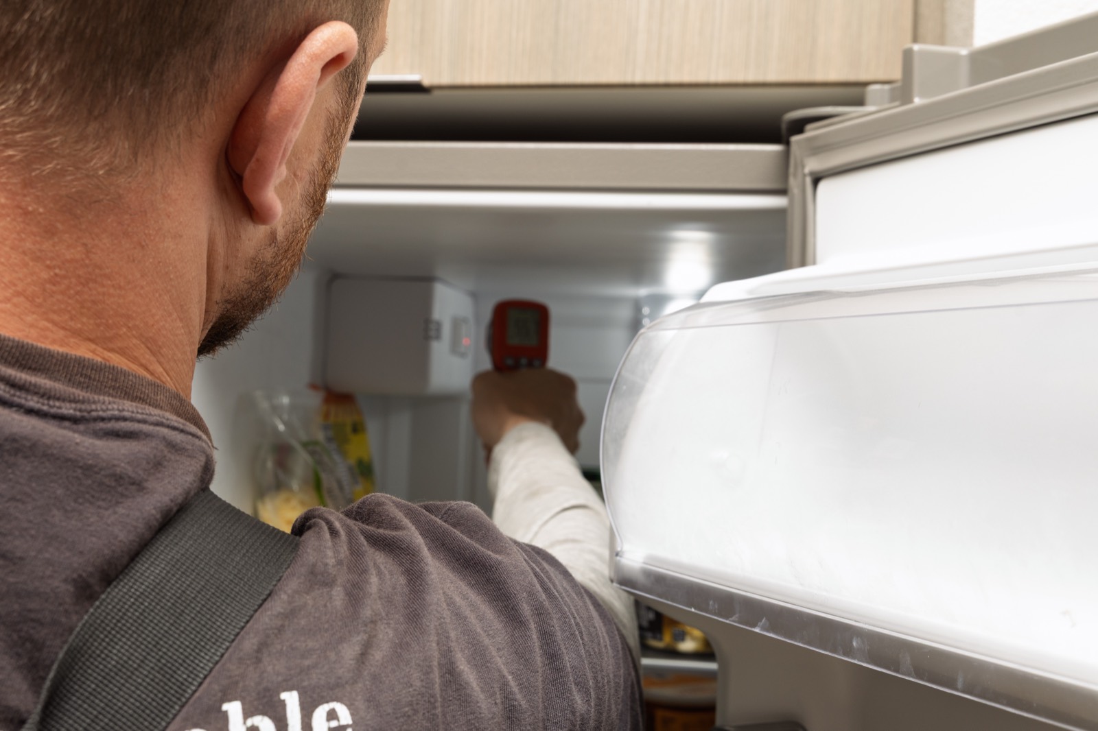 Technician diagnosing a frosted-up freezer compartment