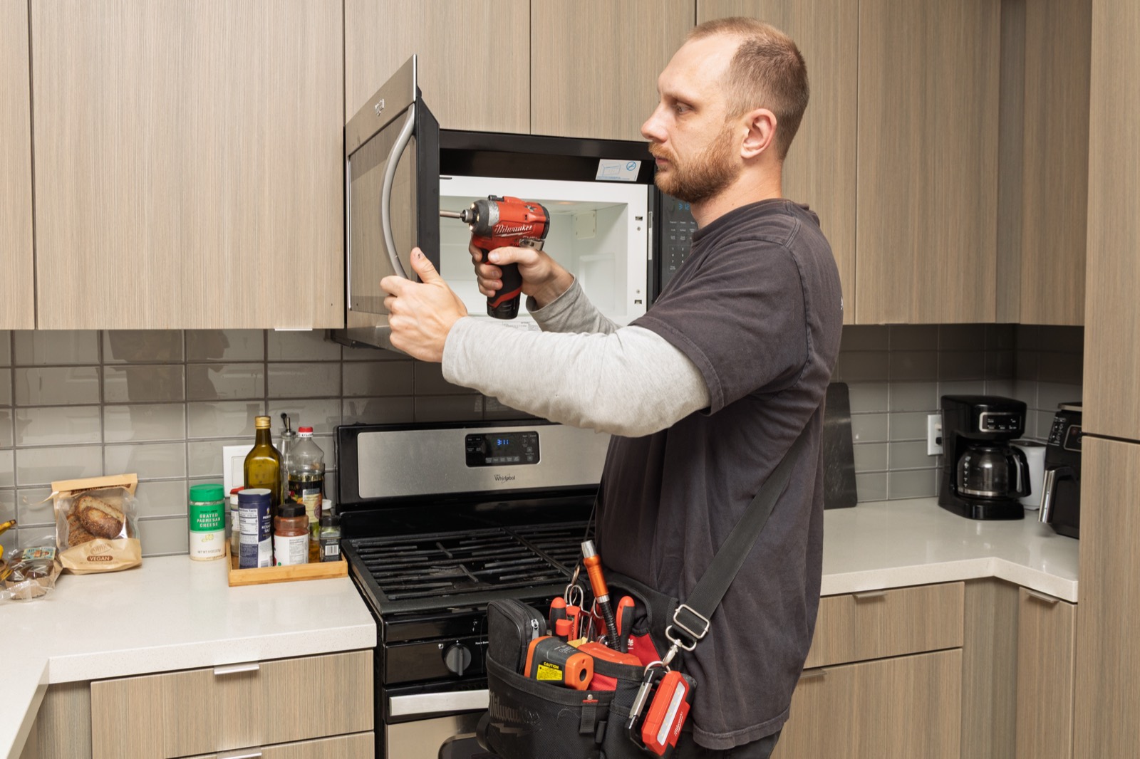Fortex technician installing an over-the-range microwave
