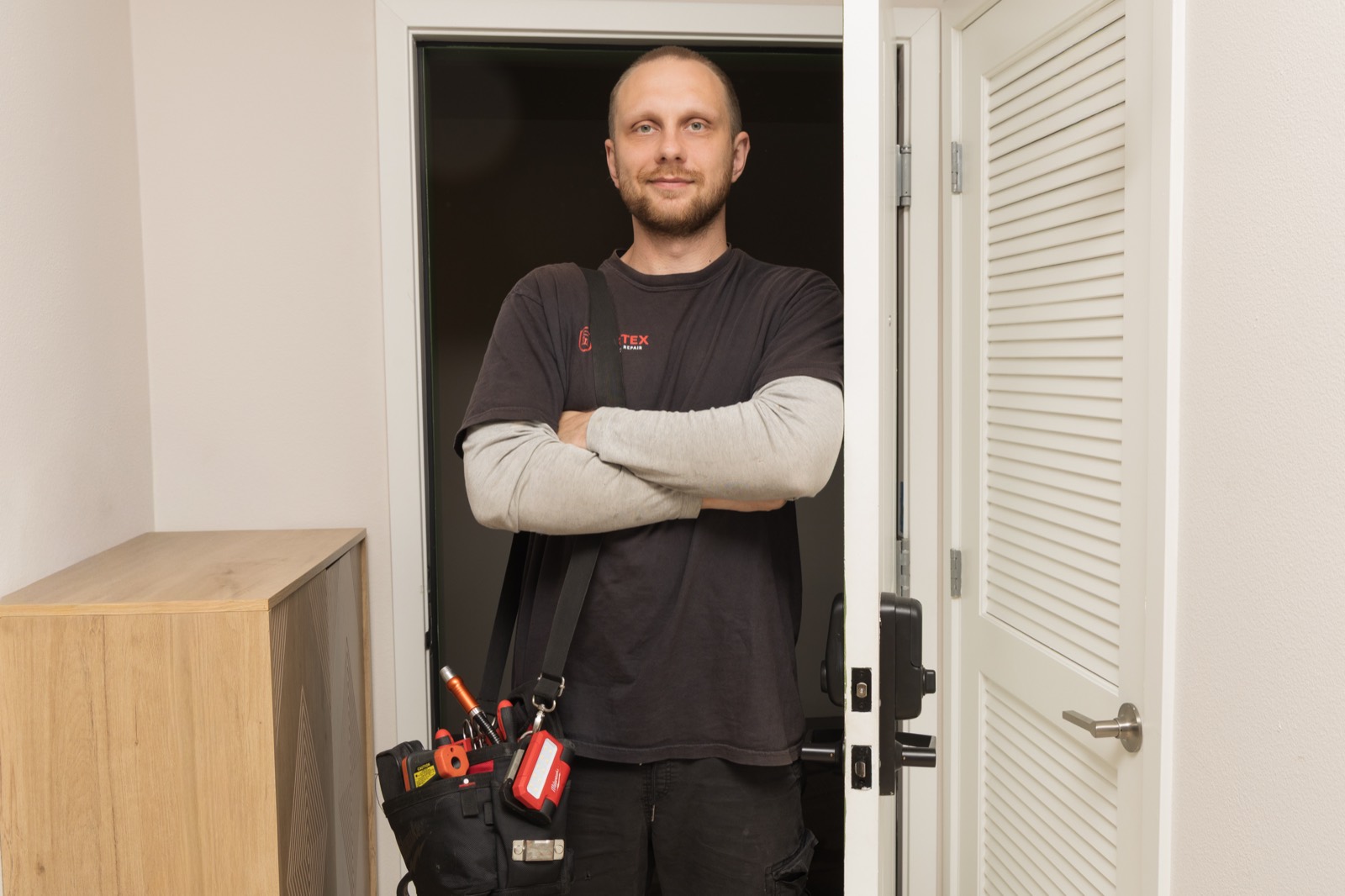 Fortex appliance repair technician standing in a doorway, arms crossed