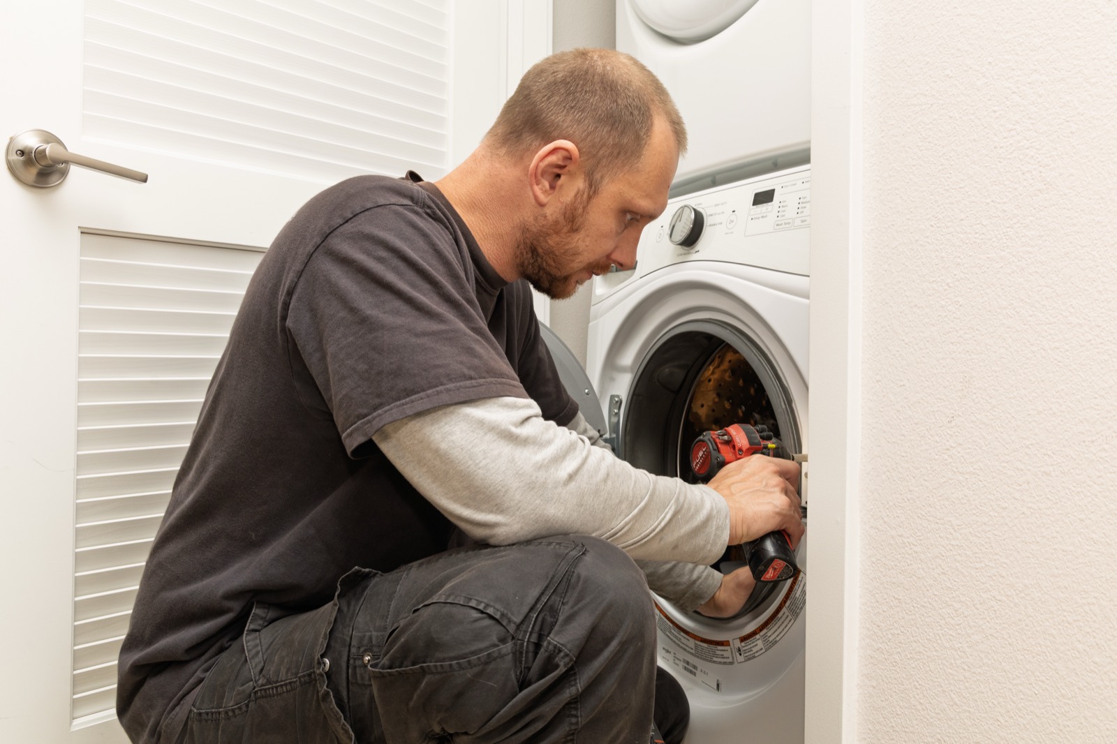 Fortex technician repairing a front-load washing machine